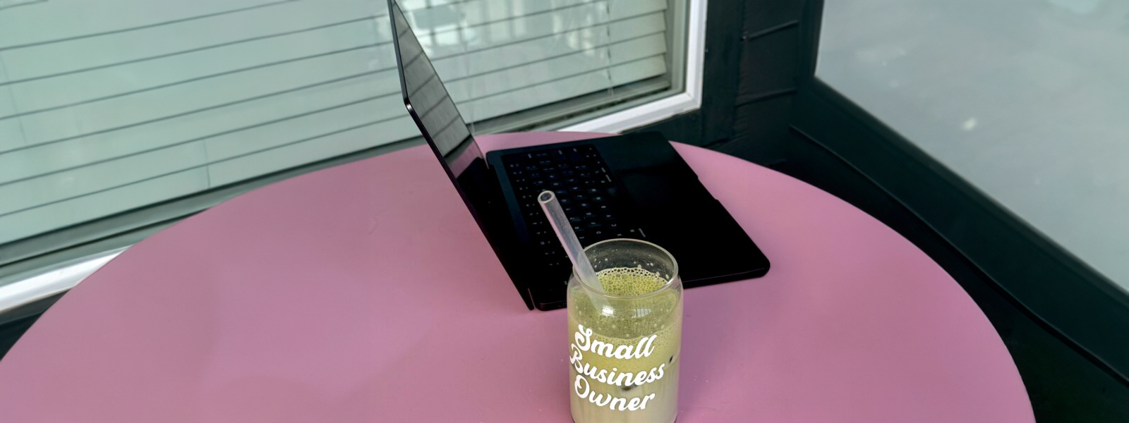 pink desk with computer with matcha