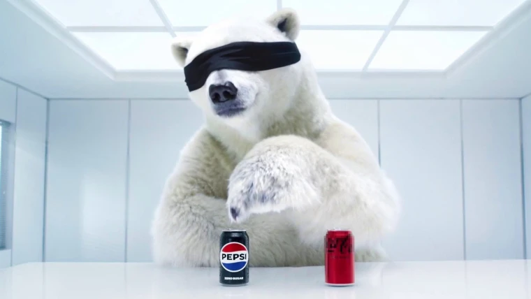 Pepsi Super Bowl Commercial advertisement with a white polar bear wearing a black blind fold with a coke and a pepsi